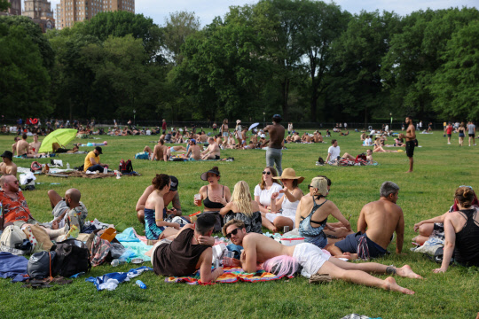 미국 뉴욕 맨해튼의 센트럴파크에서 지난달 23일(현지시간) 시민들이 마스크를 쓰지 않고 모여앉아 햇살을 즐기며 담소하고 있다. 뉴욕주는 질병통제예방센터(CDC)의 새 신종 코로나바이러스 감염증(코로나19) 대응 지침을 수용해 백신접종 완료자에 한해 실내외에서 '노 마스크'를 허용했다. [로이터=연합뉴스]